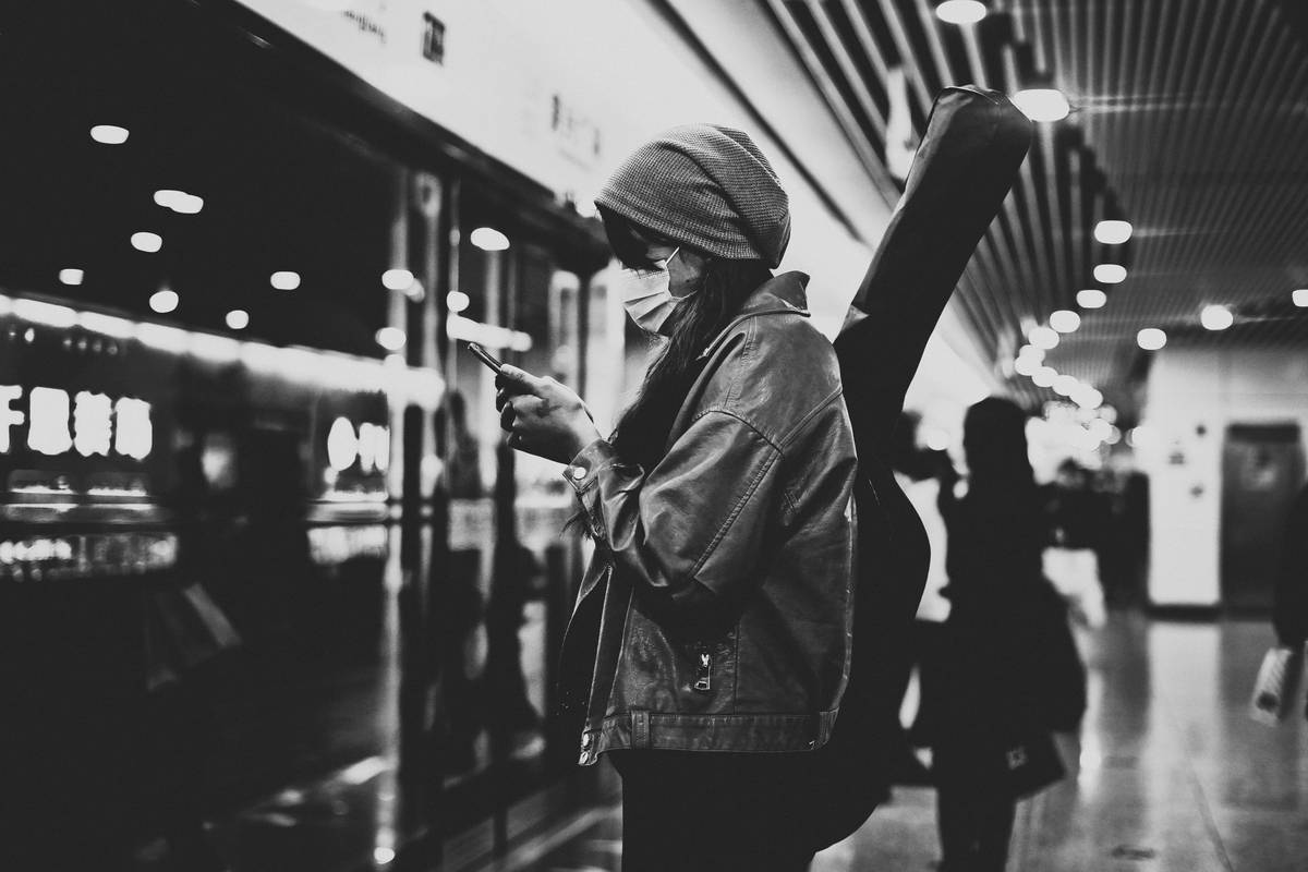 Traveler using luggage finder insurance system with GPS tracker and insurance app on smartphone
