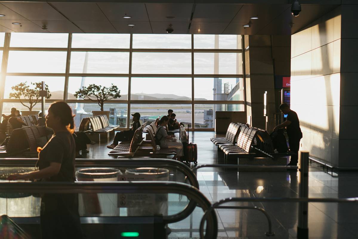 Traveler holding receipt while waiting at baggage claim with text: delay compensation ableton